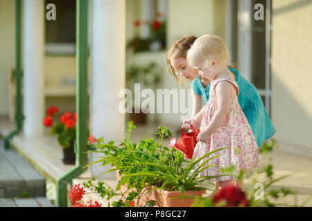 Due sorelle fiori di irrigazione in giardino Foto Stock