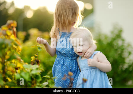 Due sorelle avendo divertimento all'aperto in estate Foto Stock