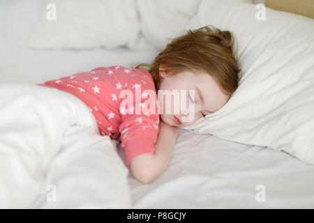 Adorabile bambina dormire in un letto Foto Stock