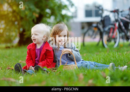 Due piccole sorelle giocare al di fuori su una bella giornata d'autunno Foto Stock