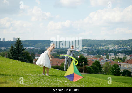 Sposa e lo sposo volare un aquilone insieme su un giorno di nozze Foto Stock