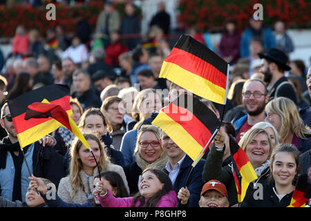 Hoppegarten, Germania, persone wave bandiere nazionali il giorno dell'unificazione tedesca Foto Stock