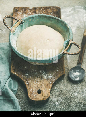 Pasta madre per la cottura in casa farina di grano pane in cesto rustico di legno su sfondo concreto, il fuoco selettivo Foto Stock