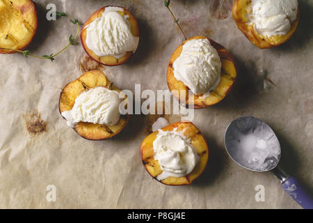 Grigliata di pesche e pesche noci servita con gelato alla vaniglia Foto Stock