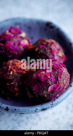 Un sano caramelle fatte di date e anacardi e coperto con petali di rosa Foto Stock