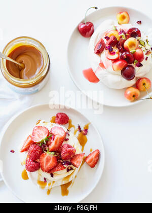 Meringhe con crema di latte e frutta fresca Foto Stock