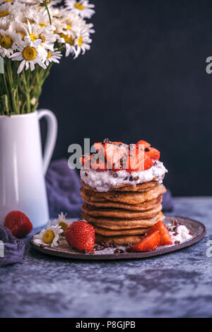 Pila di pancake con fragole e panna Foto Stock