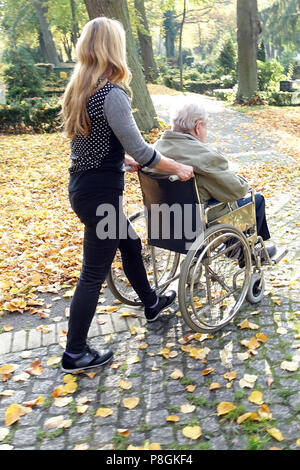 Berlino, Germania, donna spinge un vecchio uomo in sedia a rotelle Foto Stock