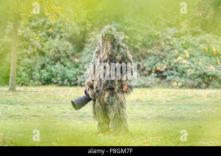 Uomo in abito ghillie, camouflage Foto Stock