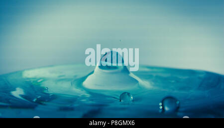 Scatti macro di gocce d'acqua in movimento catturano a mezz'aria e in superficie con temporizzazione perfetta, mostrando increspature, schizzi e la bellezza del dinamismo liquido Foto Stock
