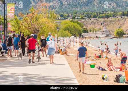 Penticton, British Columbia, Canada - Luglio 7, 2018: i turisti e la gente del posto a piedi lungo la sponda del lago e godervi la spiaggia sul lago Okanagan su una calda estate d Foto Stock