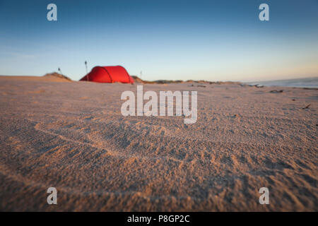 Tenda Rossa sulla spiaggia mentre il campeggio in una chiara notte. Foto Stock