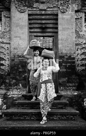 Donna balinese portano offerte in posizionedi tempio indù di pura DESA durante il GALUNGAN FESTIVAL - Ubud, Bali, Indonesia Foto Stock