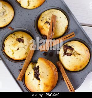 Top down shot di fresco cotto in casa senza glutine muffin alla banana con cioccolato fondente pezzi in grigio vassoio da forno Foto Stock