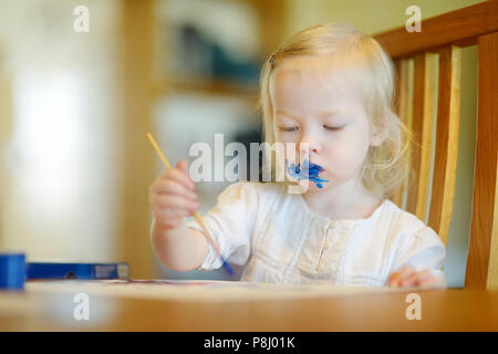 Funny sudicio toddler girl pittura in asilo nido Foto Stock