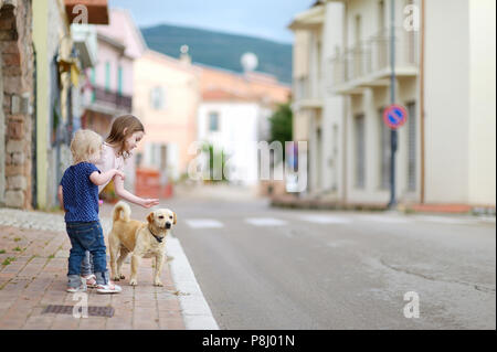 Due graziosi piccole sorelle e un cane all'aperto Foto Stock