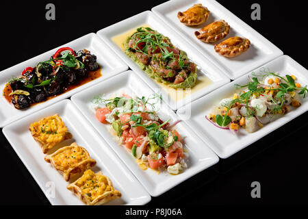 Ampia selezione di antipasti per il brunch con insalata di stagione, polpettine di carne, mini quiche, verdure cotte e tartar di pesce Foto Stock