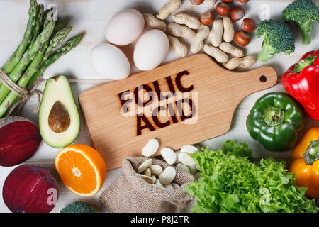 Fonti naturali di acido folico come gli asparagi, broccoli, uova, insalata di avocado, paprica, dadi, arancio, barbabietole e fagioli Foto Stock