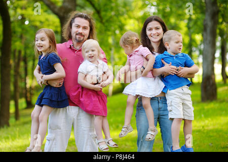 Felice la grande famiglia di sei divertendosi al summer park sulla bella giornata di sole Foto Stock