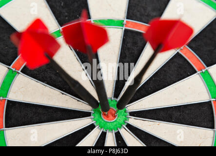 Tre freccette in un dartboard Foto Stock