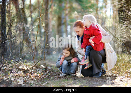 Yound bella donna e due bambine avendo divertimento passeggiate nel parco di primavera Foto Stock