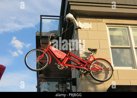 Una bicicletta rossa è sospesa sulla parete sopra il ristorante italiano "Il ladro di bicicletta', per shabby chic ristoranti sul lungomare al Vescovo di atterraggio. Foto Stock