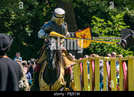 Giostra medievale, Linlithgow Palace, Scotland, Regno Unito. HES intrattenimento estivo da Les amis d'Onno equina team stunt. Cavalieri su cavalli giostra Foto Stock