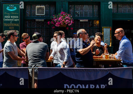 Felice, ridendo per coloro che godono di un ora di pranzo bere al di fuori del mercato Porter Pub nel mercato di Borough, Londra, Inghilterra Foto Stock