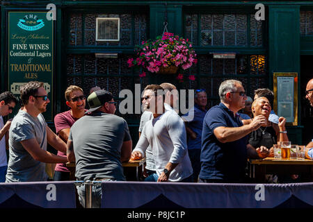 Felice, ridendo per coloro che godono di un ora di pranzo bere al di fuori del mercato Porter Pub nel mercato di Borough, Londra, Inghilterra Foto Stock