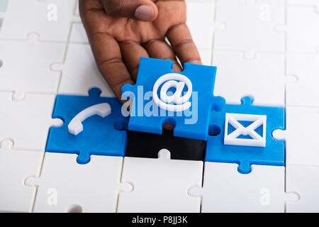 Close-up di mano azienda blu icone di posta elettronica Puzzle Foto Stock