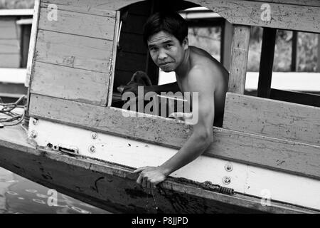 Il laotiano uomo aziona una barca sul fiume Mekong- Luang Prabang, Laos Foto Stock