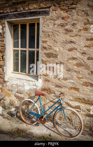 Una vecchia bicicletta nel piccolo borgo italiano Piansoave. Foto Stock