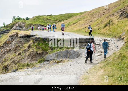 La gente che camminava sul abbandonato e rovinato road (A625) sotto Mam Tor, danneggiato da una frana, Derbyshire, England, Regno Unito Foto Stock