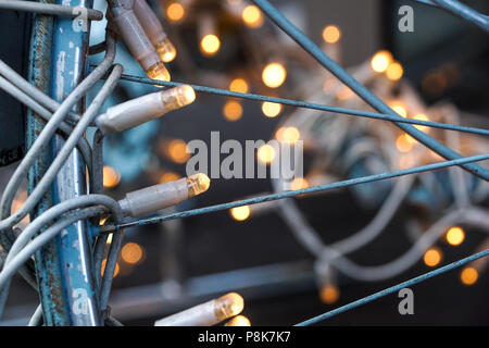 Tradizionali di Natale luci ad albero giacente su una bicicletta in metallo Foto Stock