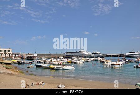 Paesaggio con un piccolo porto con spiaggia e barche sull'isola e sfondo blu cielo nuvoloso. Colori saturi Foto Stock