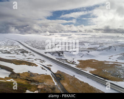 Vista aerea dell'autostrada che conduce attraverso il paesaggio innevato in Islanda Foto Stock