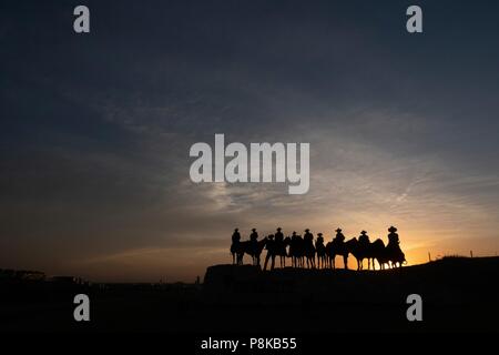 Silhouette di scultura del cowboy a cavallo al tramonto in Dodge City, Kansas Foto Stock