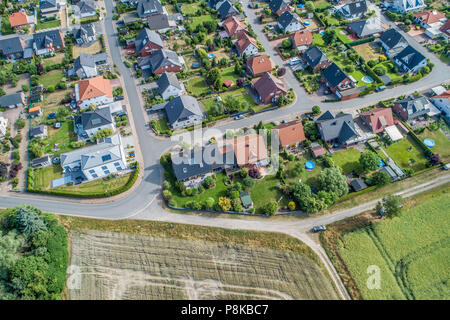 Tipico tedesco alloggiamento nuovo sviluppo nella piatta campagna della Germania del nord tra i campi e prati, fatta con drone Foto Stock