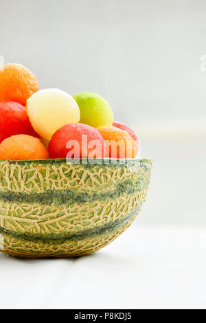 Quattro diversi tipi di melone realizzato nella sfera posto nella pelle di un secolo di melone creando una coloratissima immagine verticale con uno sfondo luminoso ad ad co Foto Stock