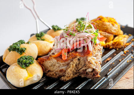 Tradizionale pasto peruviana chiamato Chicharron de Panceta de cerdo. Foto Stock