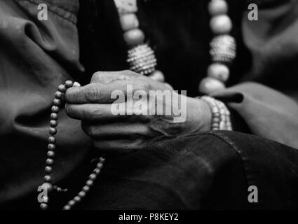 DOLPO donna perle conta sul suo rosario buddista e indossa un corallo e turchese collana in oro - Distretto di DOLPO, NEPAL Foto Stock