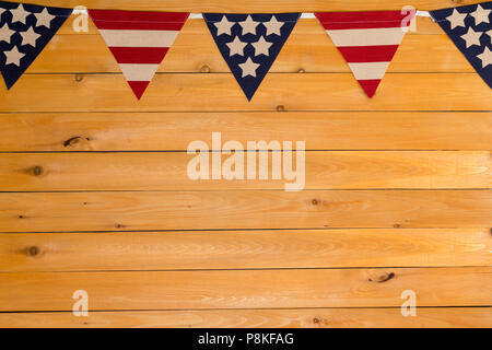 Patriottico a stelle e strisce American bunting su una ghirlanda o una stringa come un bordo superiore in legno naturale con copia spazio per Giorno Di Indipendenza Foto Stock