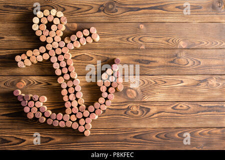 Navi decorativa formata di ancoraggio del vino utilizzato tappi disposti al lato su tavole di legno con pattern di grana di legno e spazio di copia Foto Stock