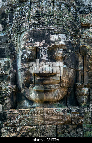 Faccia di pietra di Buddha sulla torre dell'antico tempio di Angkor Tom in Cambogia. Foto Stock