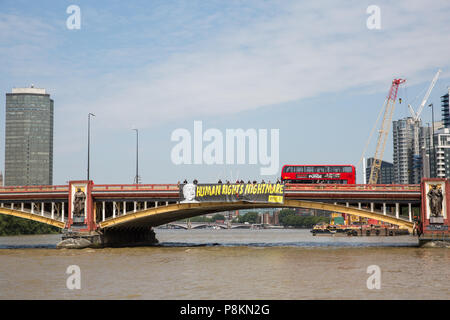 Londra, Regno Unito. 12 Luglio, 2018. Gli attivisti di Amnesty UK svelare un gigante protesta banner recanti la dicitura "Diritti umani incubo" e un'immagine di Donald Trump in vista dell'ambasciata statunitense a coincidere con l'arrivo del Presidente Trump NEL REGNO UNITO. I primi diciotto mesi del controverso Trump presidenza ha visto un periodo senza precedenti dei diritti umani il roll-back in noi. Credito: Mark Kerrison/Alamy Live News Foto Stock