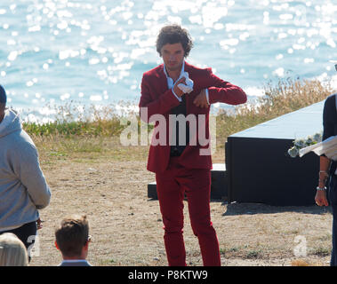 Newquay, Cornwall, Regno Unito. 12 luglio 2018. Rosamunde Pilcher attore Manuel Mairhoffer suona il pianoforte sulle scogliere,riprese 'My fratelli sposa' Fistral Beach,UK, 12th, Luglio 2018 Robert Taylor/Alamy Live News. Newquay, Cornwall, Regno Unito. Credito: Robert Taylor/Alamy Live News Foto Stock