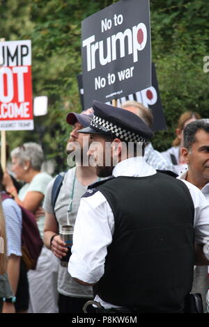 Londra, UK, 12 luglio 2018. Un poliziotto controlli anti-Trump manifestanti fuori la residenza dell'Ambasciatore, come il Presidente degli Stati Uniti in visita nel Regno Unito. Roland Ravenhill/Alamy Live News Foto Stock