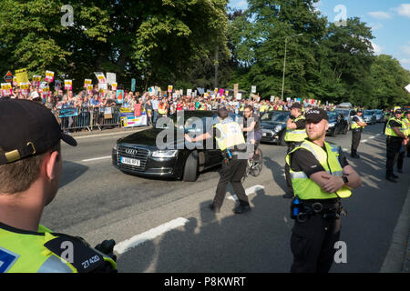 Gli ospiti arrivano a cena a Blenheim con il Presidente Trump. Essi hanno dovuto passare attraverso una grande folla di oltre due mila gridando manifestanti che hanno espresso il loro disappunto presso la visita del Presidente. Credito: Adrian arbib/Alamy Live News Foto Stock