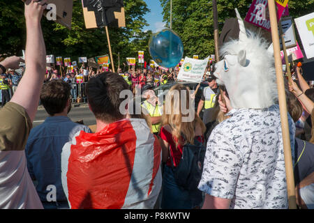 Gli ospiti arrivano a cena a Blenheim con il Presidente Trump. Essi hanno dovuto passare attraverso una grande folla di oltre due mila gridando manifestanti che hanno espresso il loro disappunto presso la visita del Presidente. Credito: Adrian arbib/Alamy Live News Foto Stock