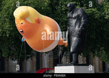 Londra - 13 Luglio: Un Donald Trump baby palloncino, vola accanto alla statua di Winston Churchill in piazza del Parlamento a Londra il 13 luglio 2018, durante la visita al Regno Unito dal presidente degli Stati Uniti, Donald Trump. Foto di David Levenson Credito: David Levenson/Alamy Live News Foto Stock